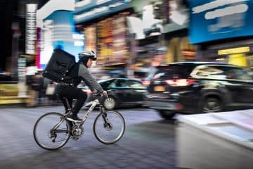 man riding bicycle near vehicles